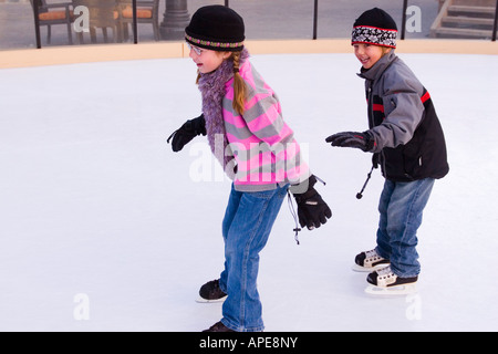 Bruder und Schwester jagten einander während des Skatens in Northstar-Ski-Resort in der Nähe von Truckee, Kalifornien Stockfoto