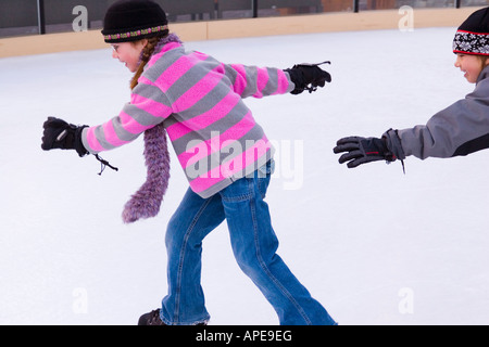 Bruder und Schwester jagten einander während des Skatens in Northstar-Ski-Resort in der Nähe von Truckee, Kalifornien Stockfoto