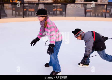 Bruder und Schwester jagten einander während des Skatens in Northstar-Ski-Resort in der Nähe von Truckee, Kalifornien Stockfoto