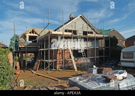Baustelle mit freistehendem Haus im Bau und laufende Arbeiten mit Dachziegeln an einem kalten Wintertag 3xyz Essex England UK Stockfoto