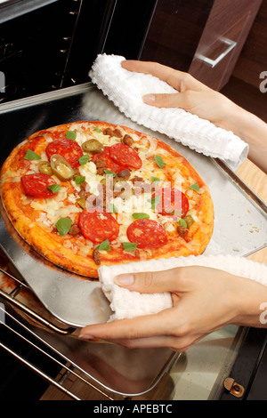 PIZZA ENTFERNEN AUS DEM OFEN Stockfoto