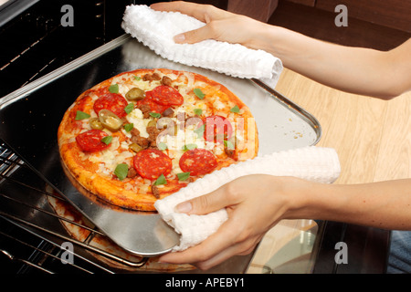 PIZZA ENTFERNEN AUS DEM OFEN Stockfoto