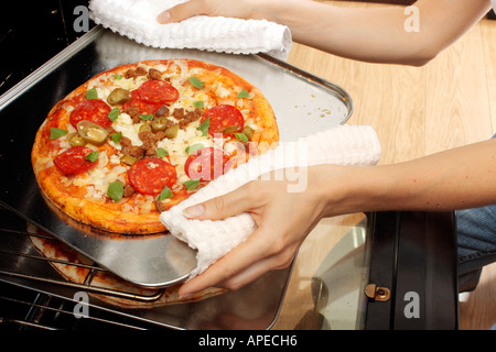 PIZZA ENTFERNEN AUS DEM OFEN Stockfoto