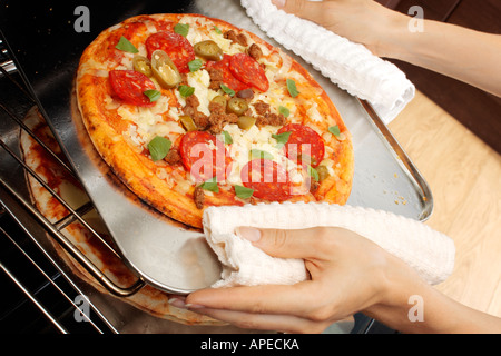 PIZZA ENTFERNEN AUS DEM OFEN Stockfoto