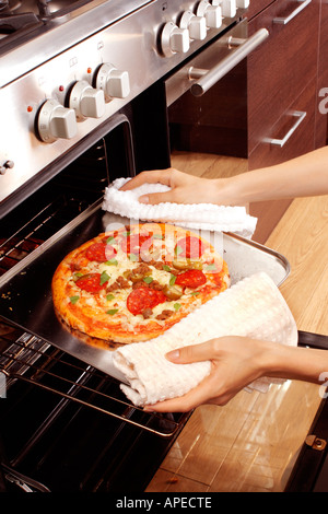 PIZZA ENTFERNEN AUS DEM OFEN Stockfoto