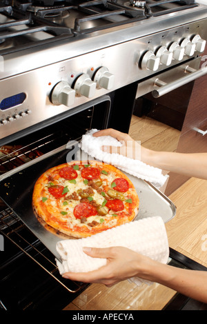 PIZZA ENTFERNEN AUS DEM OFEN Stockfoto