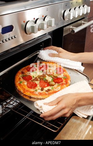 PIZZA ENTFERNEN AUS DEM OFEN Stockfoto