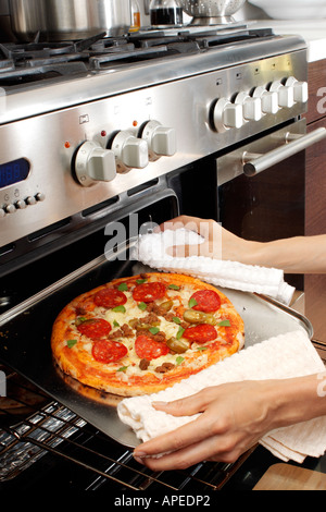 PIZZA ENTFERNEN AUS DEM OFEN Stockfoto