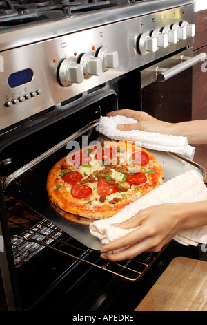 PIZZA ENTFERNEN AUS DEM OFEN Stockfoto