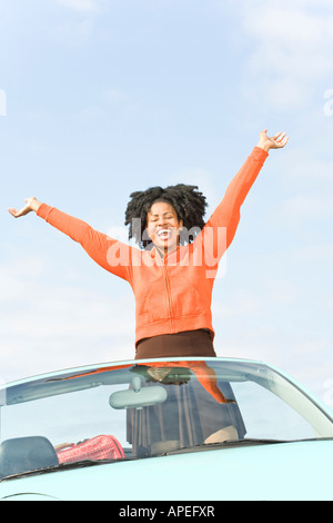 Afrikanerin mit Cabrio erhobenen Armen Stockfoto