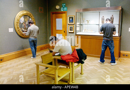 Schüler bei einer Kunstausstellung in einer Galerie in das National Museum Cardiff South Wales UK skizzieren Stockfoto