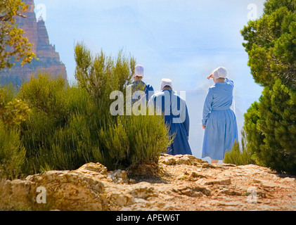 Amische Mädchen in traditionellen blauen Kleid und weiße Hüte mit Blick auf den Grand Canyon auf Sims mit Metall Geländer. (2) Stockfoto