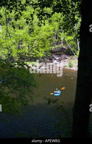 Mann auf der blauen Kajak Suche bei großen brook Gießen in Fluss über Felsen. Stockfoto