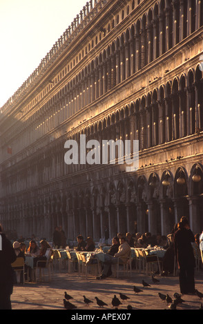 VENEDIG, ITALIEN. Cafés und Gebäude am Piazza San Marco (Markusplatz entfernt), mit Menschen, einige Wintersonne genießen. 2004. Stockfoto