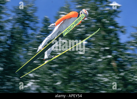 Skispringer in der Luft mit Bäumen Stockfoto