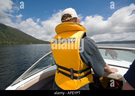 Teenager in Rettungsweste Powerboating auf Lake Brunner Stockfoto