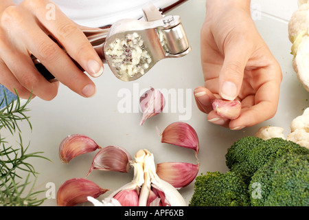 FRAU IN DER KÜCHE ZERKLEINERN KNOBLAUCH Stockfoto