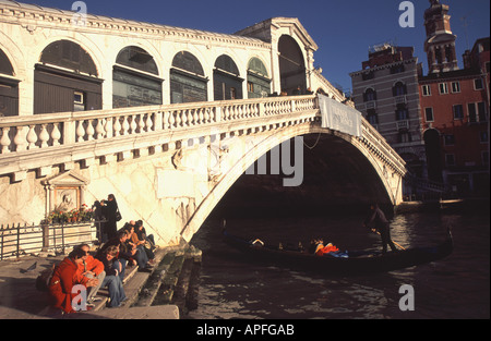 VENEDIG, ITALIEN. Der Canal Grande und die Rialto-Brücke aus Fondamenta del Vin, mit Touristen einige Wintersonne genießen. Stockfoto