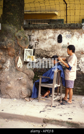 Mann immer einen Haarschnitt, Seitenstraßen von Hanoi, Vietnam. Stockfoto