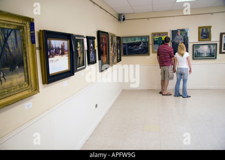 Ein paar hört auf zu viele Kunstwerke auf dem Display auf diese Art Exhibit an der Utah State Fair in SLC, Utah, USA zu schätzen wissen. Stockfoto