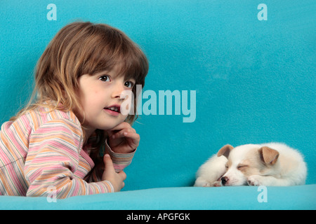 Porträt eines jungen Mädchens liegen neben einem schlafenden Mischling Welpen Stockfoto