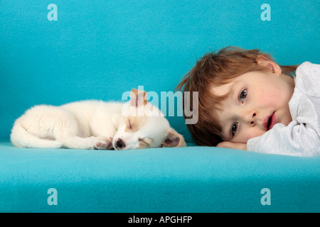 Porträt eines jungen Mannes liegen neben einem schlafenden Mischling Welpen Stockfoto