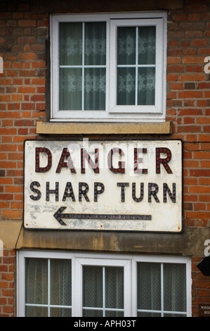 Ein Haus, das auf einer scharfen Kurve durch ein großes Schild mit der Aufschrift "Zorn scharfe Kurve" geschützt ist. Bild von Jim Holden Stockfoto