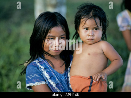 Eine junge Inderin Boras und ihre kleine Schwester in ihrem abgelegenen Regenwald Dorf entlang des Amazonas in Peru in der Nähe von Iquitos Stockfoto