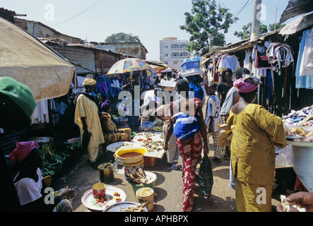 Eine afrikanische Frau geht mit ihrem Baby auf dem Rücken durch den Markt in Serekunda die größte Stadt in Gambia Stockfoto