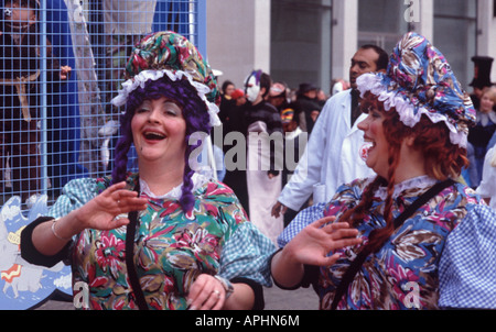 Zwei lustige Zwilling Frauen in geblümten Kleidern und Rüschen mit Fransen Kappen Lachen und winken in Lord Mayor es Show, City of London Stockfoto