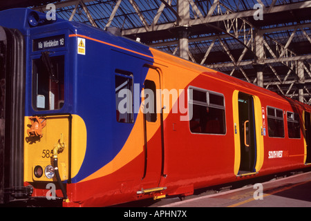 Elektrische Pendler zu trainieren, Motor und Wagen mit leuchtend rot, gelb, orange und blau Lackierung und hohe Sichtbarkeit Tür Markierungen Stockfoto