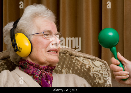 Ältere Dame tragen Ohr ^ Verteidiger und selbstgefälligen Blick Stockfoto