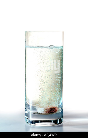 Eine Brause Tablette mit Vitaminen und Mineralien auflösen in einem Glas mit frischem Wasser Stockfoto