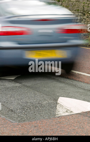 Ein Auto über eine Geschwindigkeit Buckel In ein AA finanzierte Studie solche Verkehrsberuhigungsmaßnahmen Doppel Kohlendioxidemissionen gefunden wurden Stockfoto