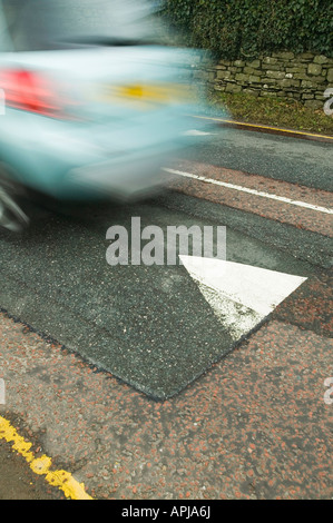 Ein Auto über eine Geschwindigkeit Buckel In ein AA finanzierte Studie solche Verkehrsberuhigungsmaßnahmen Doppel Kohlendioxidemissionen gefunden wurden Stockfoto