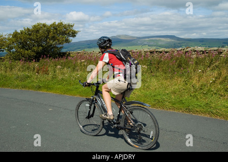 Radfahrer auf der Landstraße in der Nähe niederzulassen North Yorkshire mit Ingleborough am Horizont Stockfoto