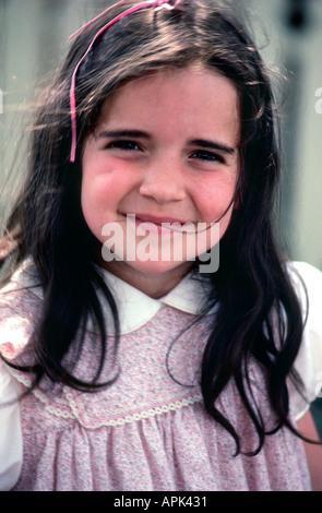 Schöne 5 Jahre altes Mädchen mit Grübchen und lange braune Haare mit rosa Haarband Stockfoto