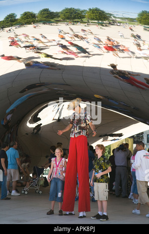 ILLINOIS-Chicago-Mann auf Stelzen stellen mit zwei Kindern vor der Skulptur Cloud Gate Bean Millennium Park Reflexionen Stockfoto