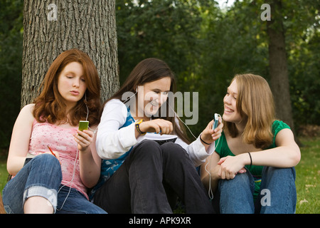 ILLINOIS Riverwoods drei Teenager sitzen in grass iPod Musik hören und teilen Kopfhörer Stockfoto