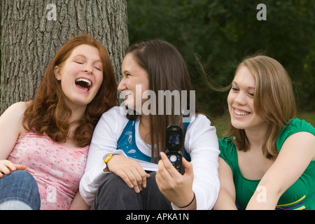 ILLINOIS Riverwoods drei Teenager sitzen zusammen vor Lachen gelehnt Baumstamm blonde redhead Stockfoto