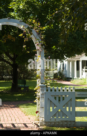 ILLINOIS Grand Detour White Fence und Bogen mit Rebe über Ziegel Bürgersteig bei John Deere historischen Ort White home im Hintergrund Stockfoto