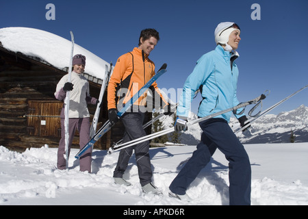 drei Langläufer mit Ausrüstung vor einer Almhütte, Österreich Stockfoto