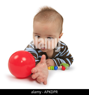 Baby, die versuchen, einen Ball zu packen Stockfoto