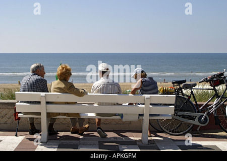 Touristen sitzen auf einer Bank an der Strandpromenade von Zandvoort, Blick aufs Meer, Niederlande, Zandvoort Stockfoto