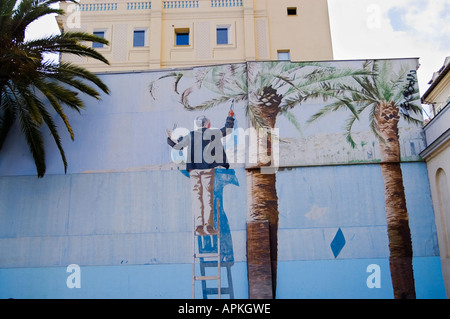 Wandbild von einem Mann auf einer Leiter malen ein Wandbild, Quai des Etats-Unis, Nizza, Frankreich Stockfoto