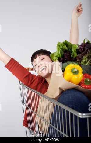 Frau im Supermarkt-Einkaufswagen Stockfoto