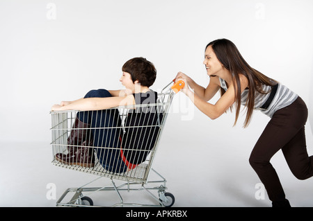 Zwei Frauen spielen mit einem Lebensmittelgeschäft-Wagen Stockfoto