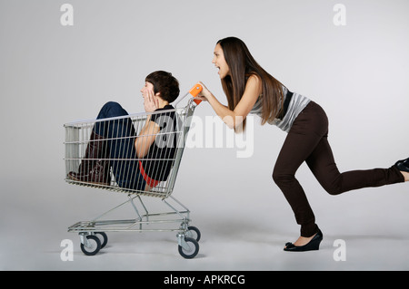 Zwei Frauen spielen mit einem Lebensmittelgeschäft-Wagen Stockfoto