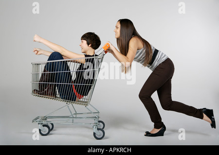 Zwei Frauen spielen mit einem Lebensmittelgeschäft-Wagen Stockfoto
