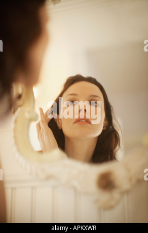Frau zur Festsetzung der Haare vor dem Spiegel Stockfoto